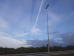 Contrail veroorzaakt door een vliegtuig met schaduw door de laagstaande zon